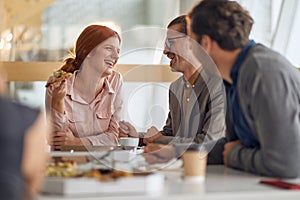 Employees eating pizza together at lunch break at company canteen. People, job, company, business concept