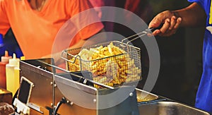 Employees frying french fries with hot oil. Selling food on the street