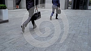 Employees hurrying to important meeting in business center, time-management