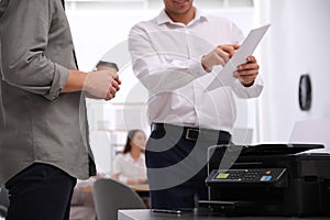 Employees near modern printer in office, closeup