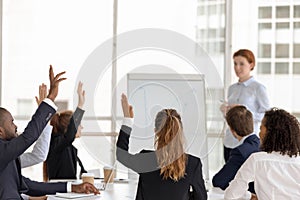 Employees raise hands answering questions at office training