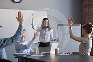 Employees raise hands taking part in teambuilding activity