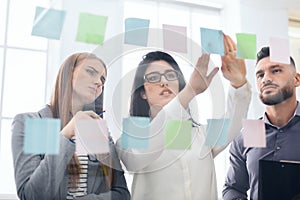 Employees sticking reminders on visualization board in office