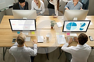 Employees using computers working with staff in office, top view