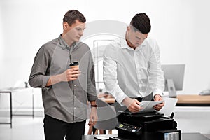 Employees using new modern printer in office