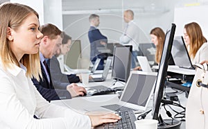 Employees work on laptops in the workplace