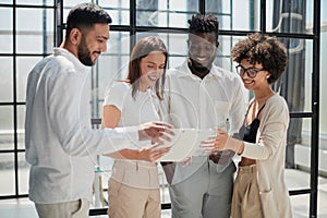 Employees working at computer together, discussing content