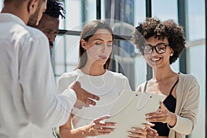 Employees working at computer together, discussing content