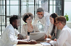 Employees working at computer together, discussing content