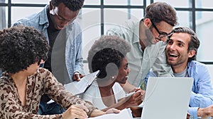 Employees working at computer together, discussing content