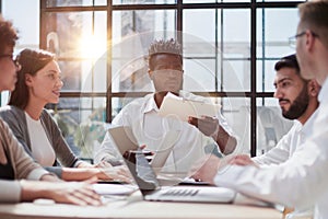 Employees working at computer together, discussing content