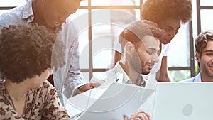 Employees working at computer together, discussing content