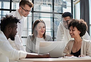 Employees working at computer together, discussing content