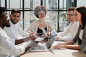 Employees working at computer together, discussing content