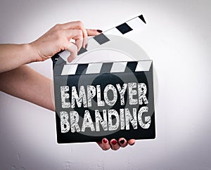 Employer Branding. Female hands holding movie clapper photo