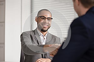 Employer handshake smiling male candidate congratulating with hiring