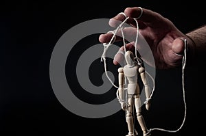 Employer manipulating the employee, emotional manipulation and obey the master concept with ominous hand pulling the strings on a photo