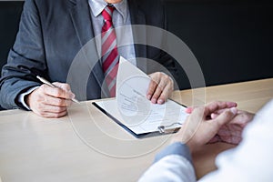 Employer or recruiter holding reading a resume during about colloquy his profile of candidate, employer in suit is conducting a