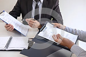 Employer or recruiter holding reading a resume during about colloquy his profile of candidate, employer in suit is conducting a