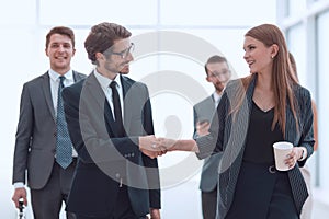 employer shaking hands with a young employee.