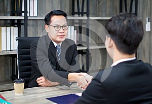 Employers shake hands to congratulate candidate after the interview. The atmosphere of job interview in the modern office