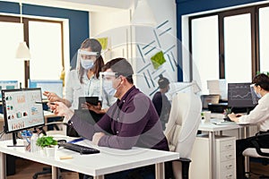 Employess working together wearing face mask as safety precaution