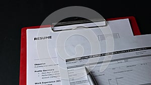 Employment Application form on top of resume on office table.
