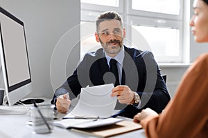 Employment concept. Businessman having job interview and talking with woman headhunter sitting at desk in office