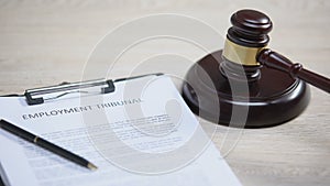 Employment tribunal document on table, gavel striking on sound block, labour law