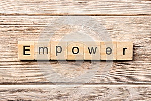 Empower word written on wood block. empower text on table, concept