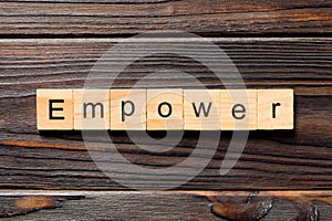 Empower word written on wood block. empower text on table, concept