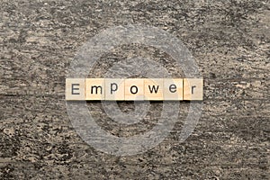 empower word written on wood block. empower text on table, concept