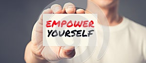 EMPOWER YOURSELF, message on the card shown by a man