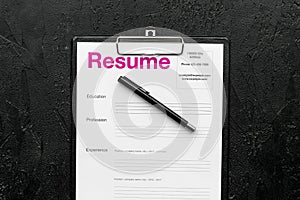 Empoyment concept. Resume on pad near pen and glasses on black background top view