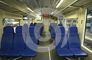 Empty 2 class compartment of wagon of commuter train, seats and doors