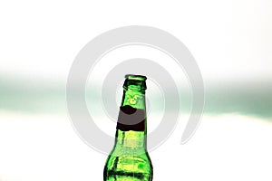 Empty 33cl bottle of beer close up, edited; sea view background. iconic image