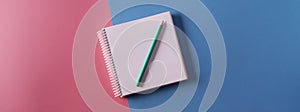 An empty A4 notebook on a pink and blue paper background, top view,mockup
