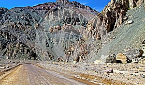 Empty adventurous lonely dirt road on the chilean pacific coast between rough rugged rocks in lonely dry desert area - Pan de