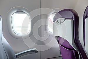 Empty air plane seats and window providing space for place text. Modern airplane interior