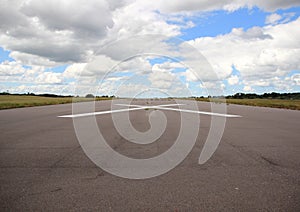 Empty airplane runway with white cross