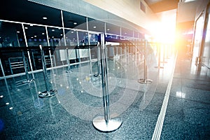 Empty airport check-in line lit by sun beam