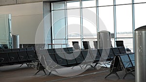 Empty airport terminal lounge. Empty airport seating - typical black chairs in boarding waiting