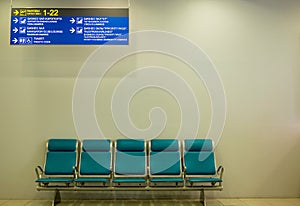 Empty airport terminal waiting area with chairs