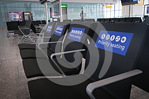 Empty airport waiting terminal priority seats.