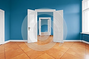 Empty apartment room with blue walls and parquet floor