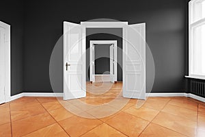 Empty apartment room with open doors and parquet floor