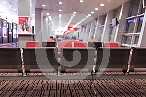 Empty armchairs in hall of expectation of airport and plane behind window