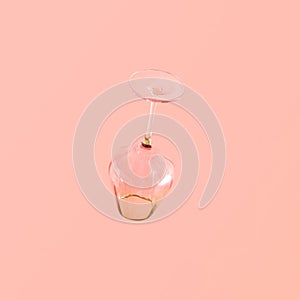 Empty Art Deco glass against pastel pink background, lux lifestyle concept