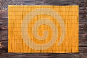 Empty Asian Food Background. Yellow Bamboo mat on wooden background top view with copy space flat lay