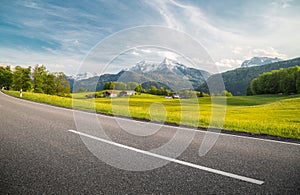 Empty asphalt country road with alpine mountain scenery in summer